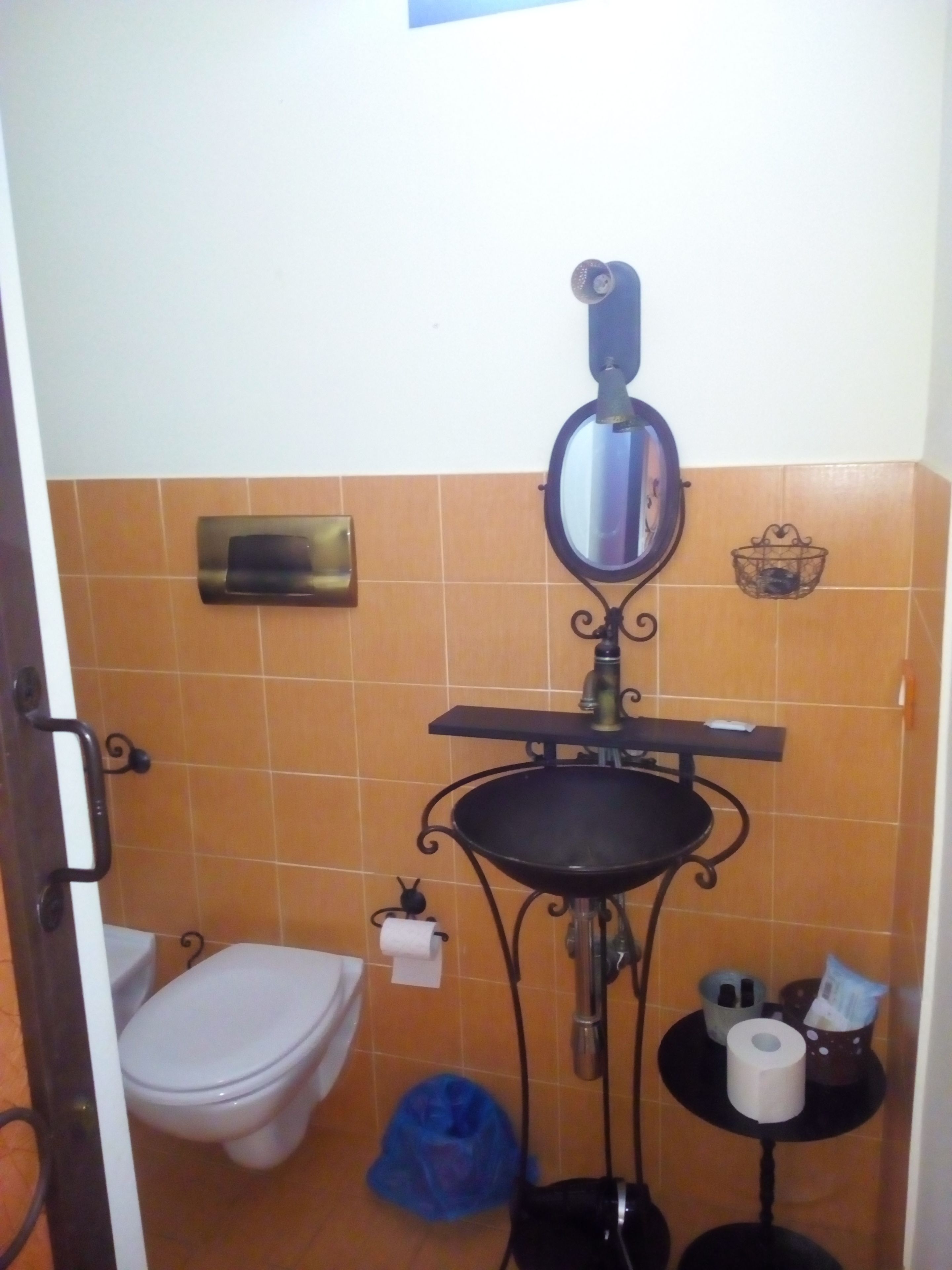 Ein kleines Badezimmer mit Toilette, Waschbecken und Spiegel.