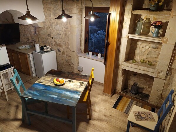 Una cocina rústica con pared de piedra, muebles de madera y ventana con vistas.
