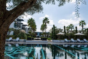 Una piscina al aire libre, sillones reclinables de piscina