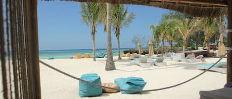En la playa, playa de arena blanca, camastros y sombrillas