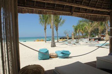 On the beach, white sand, sun-loungers, beach umbrellas