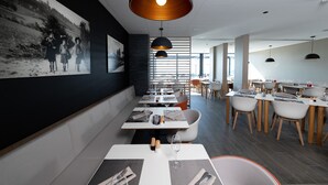 A modern restaurant interior with high tables, comfortable seating, and large pendant lights. - Le Floreal Panoramique (Tournai)