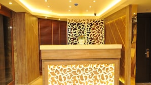 A reception desk with a decorative panel and a potted plant. - Comfort Elite Hotels Old City (Istanbul)