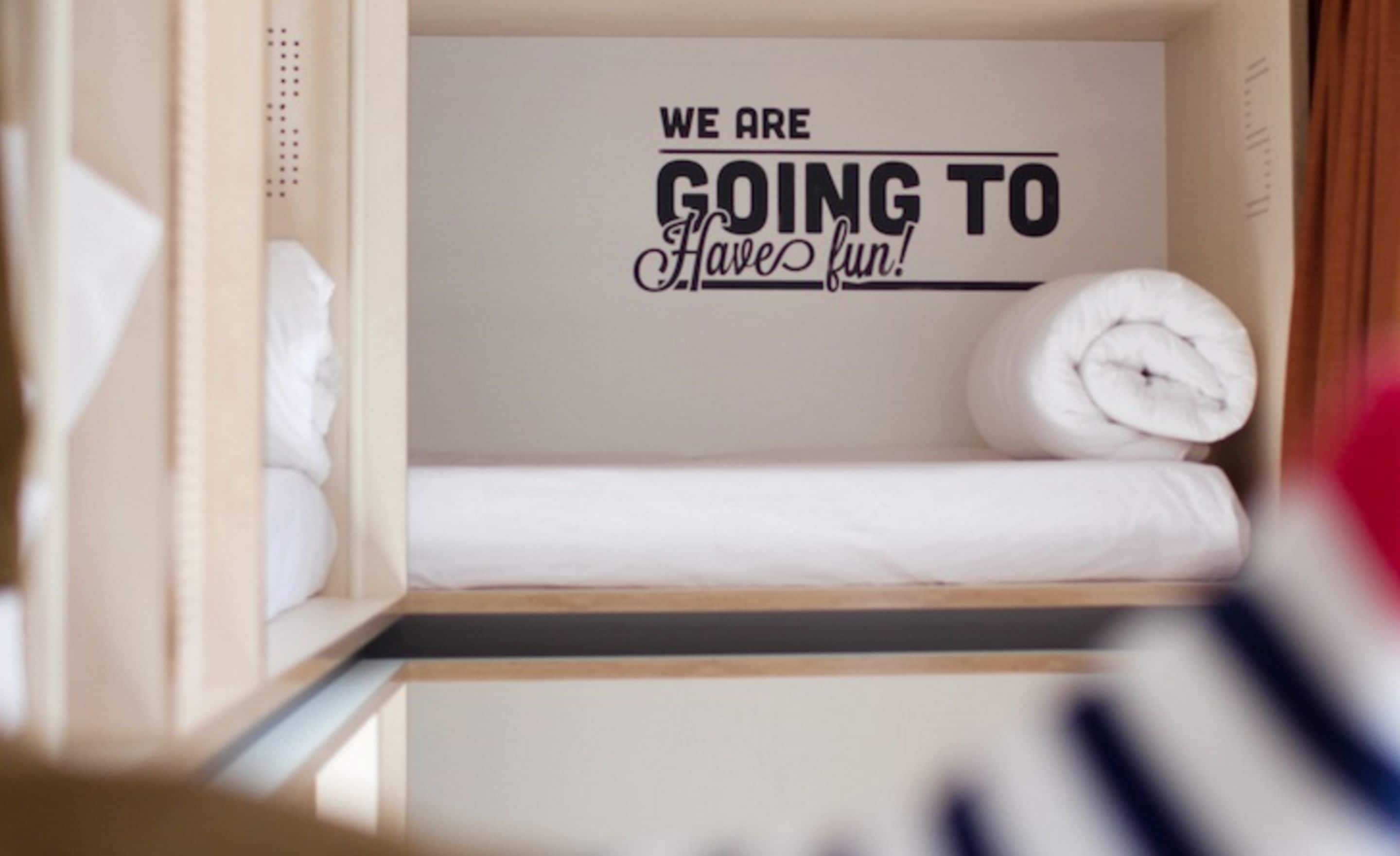 Una cama bien hecha con una frase motivadora en la pared.