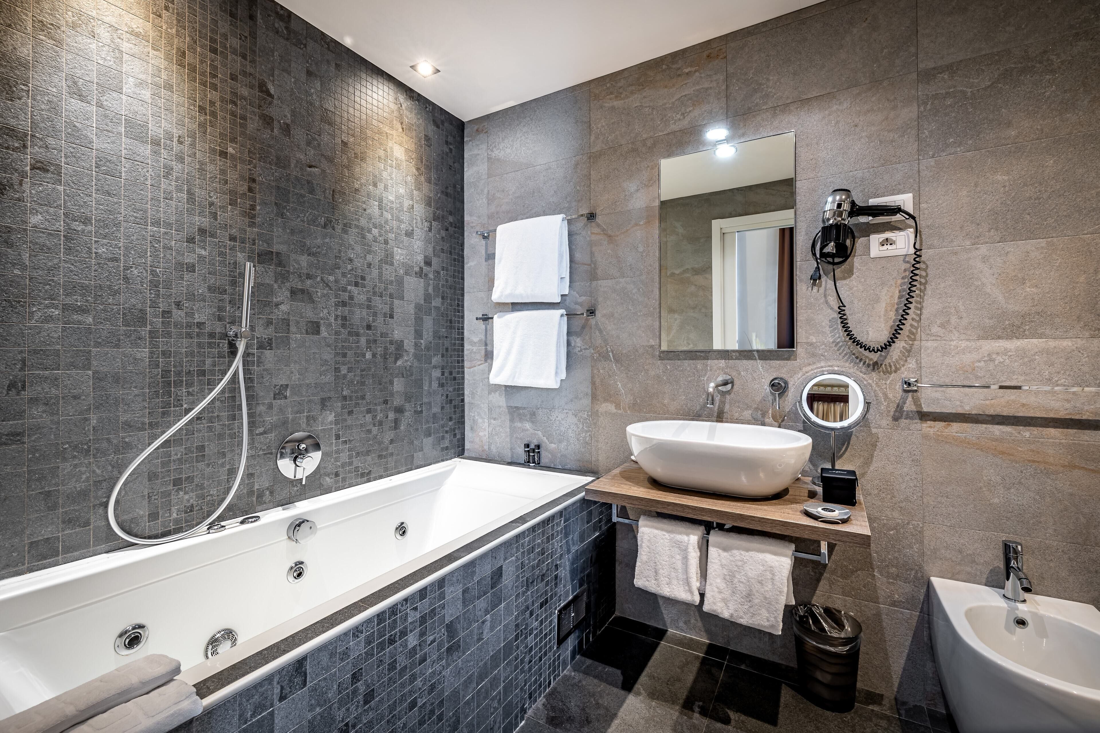 A modern bathroom with a freestanding bathtub, a vanity with a large sink, and a mirror.