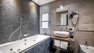 A modern bathroom with a freestanding bathtub, a vanity with a large sink, and a mirror.