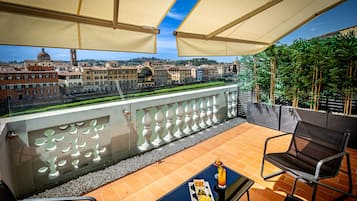 Un balcon avec une table, des chaises et un plateau de nourriture.