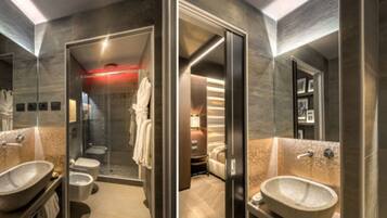 Une salle de bain moderne dotée d’une douche à parois de verre, d’un grand lavabo et d’un espace toilettes séparé.