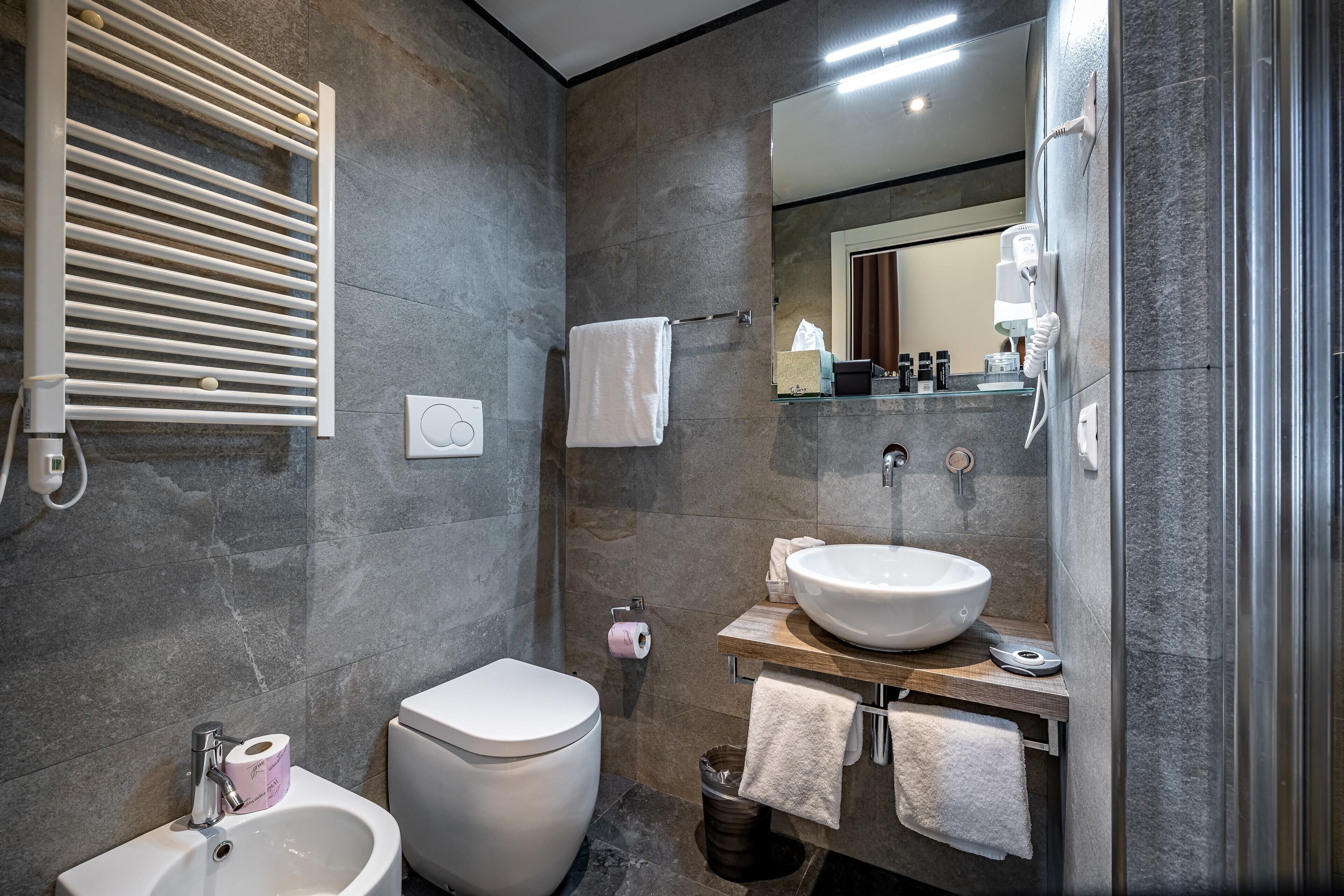 Un baño moderno con lavamanos integrado, inodoro, bidé y toallero.