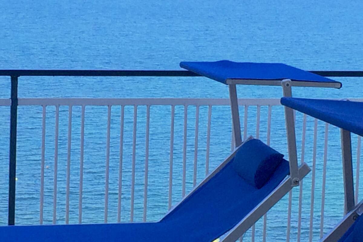 Un balcon doté d’une balustrade en métal donnant sur une étendue d’eau.