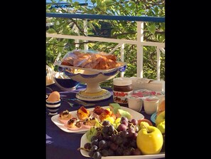 Une table où sont présentés divers aliments, notamment des pâtisseries, des fruits et des pots de Nutella.
