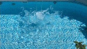 Ein Schwimmbecken mit klarem, blauem Wasser und einer Springbrunnenanlage.