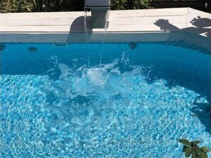 Una piscina al aire libre, tumbonas