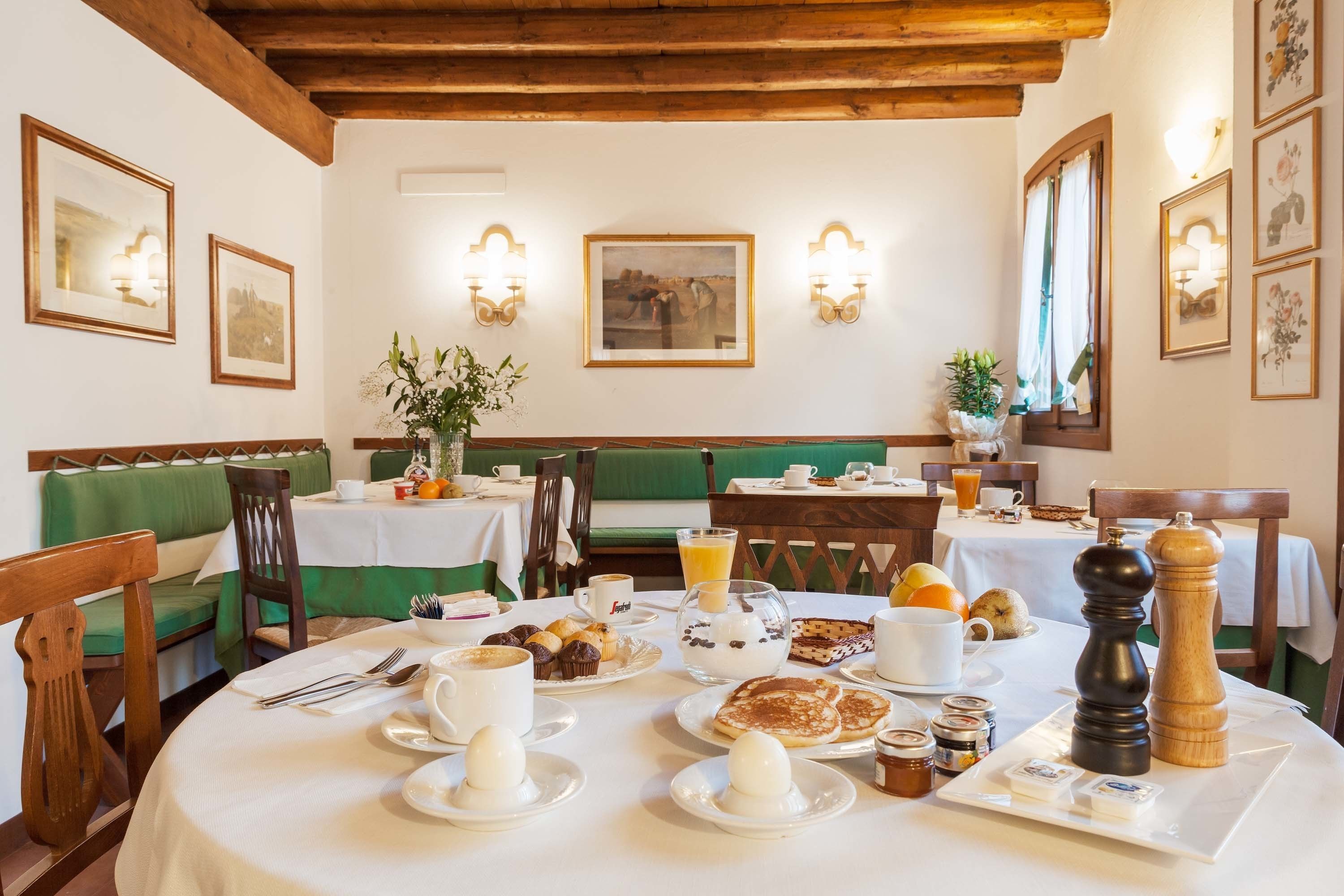 A breakfast setting with tables, chairs, and a variety of breakfast items.