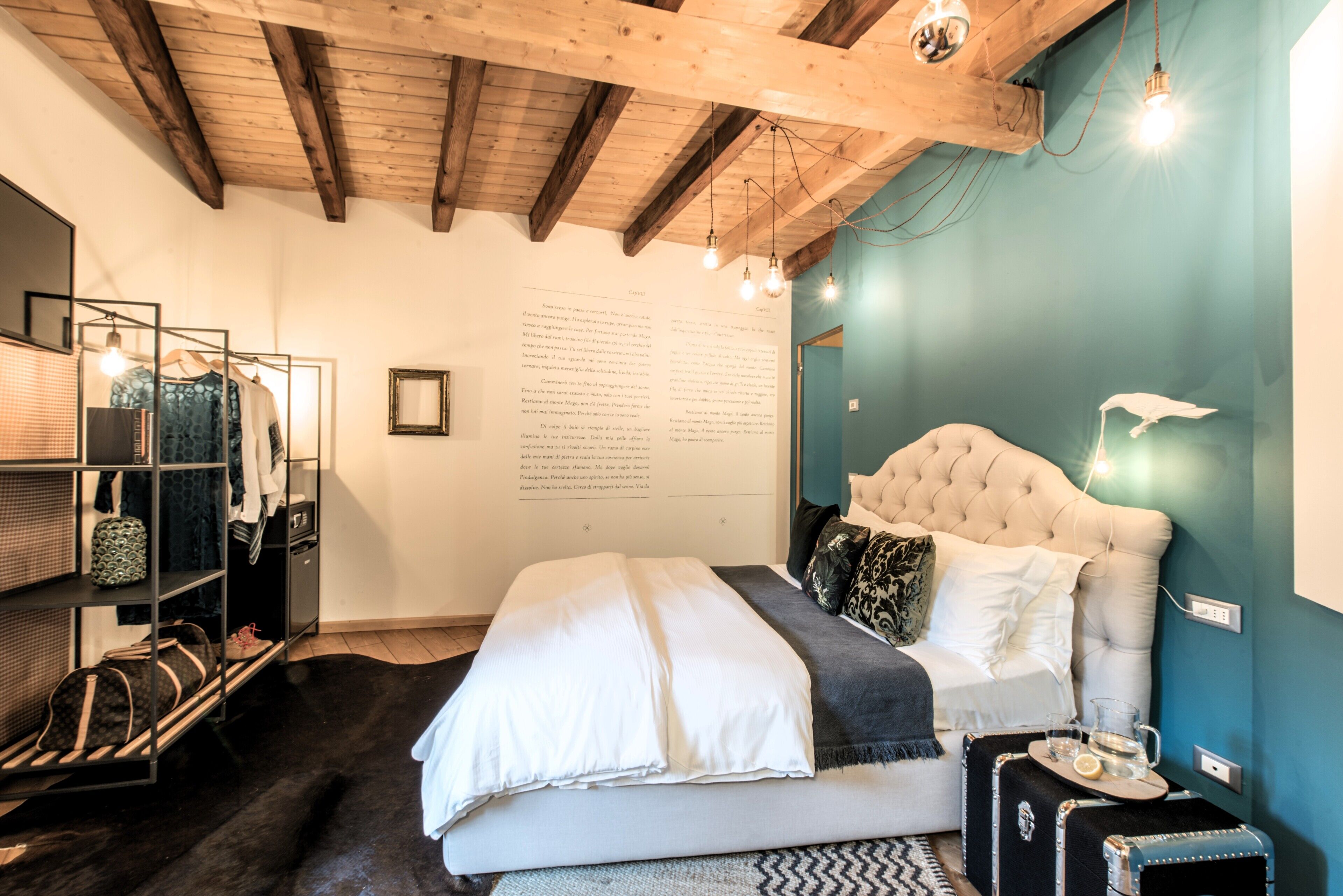 Ein Schlafzimmer mit einem Bett, einem Kleiderschrank, einem Spiegel und einer Wand mit Schrift.