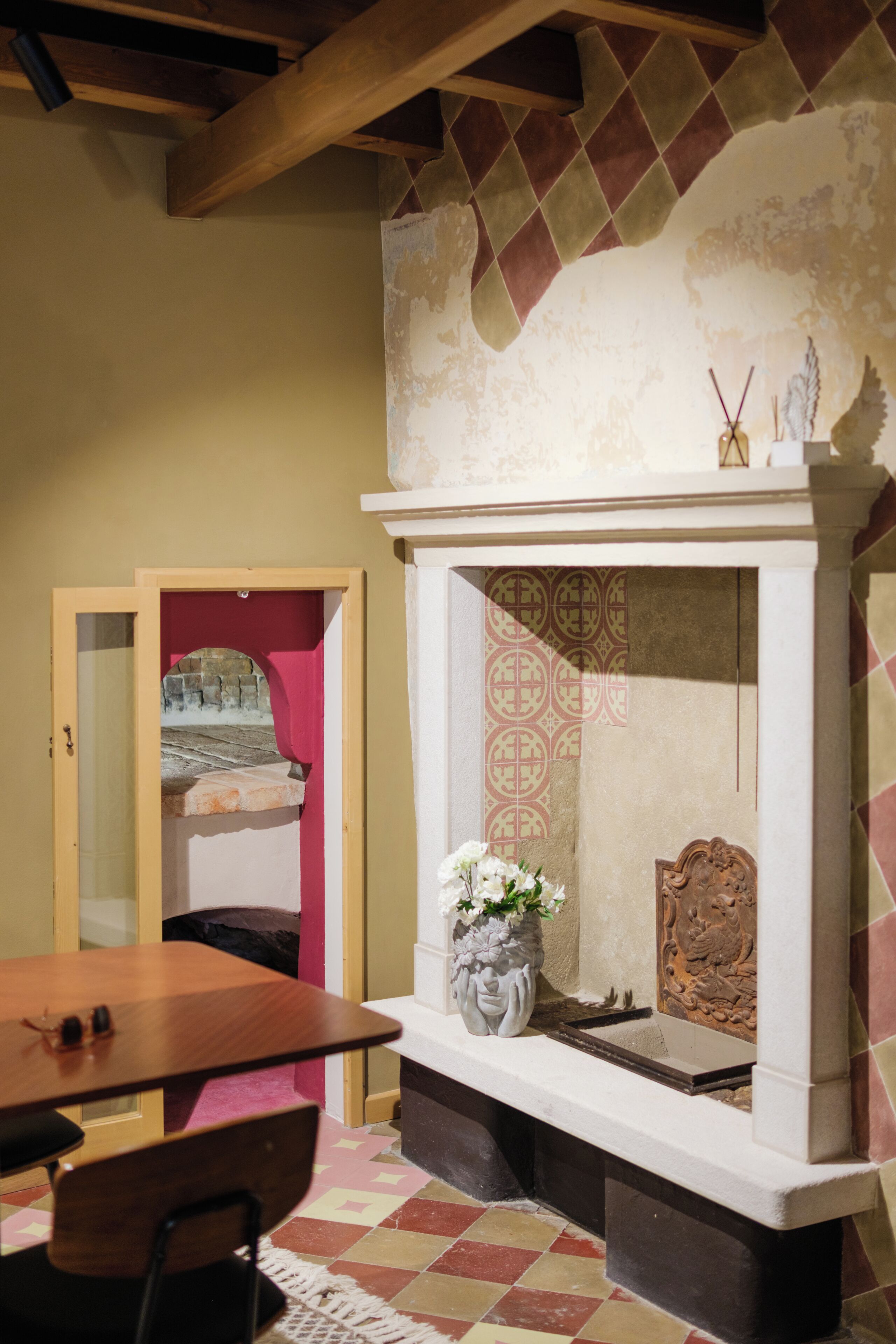 Una habitación con chimenea, una mesa y una silla.