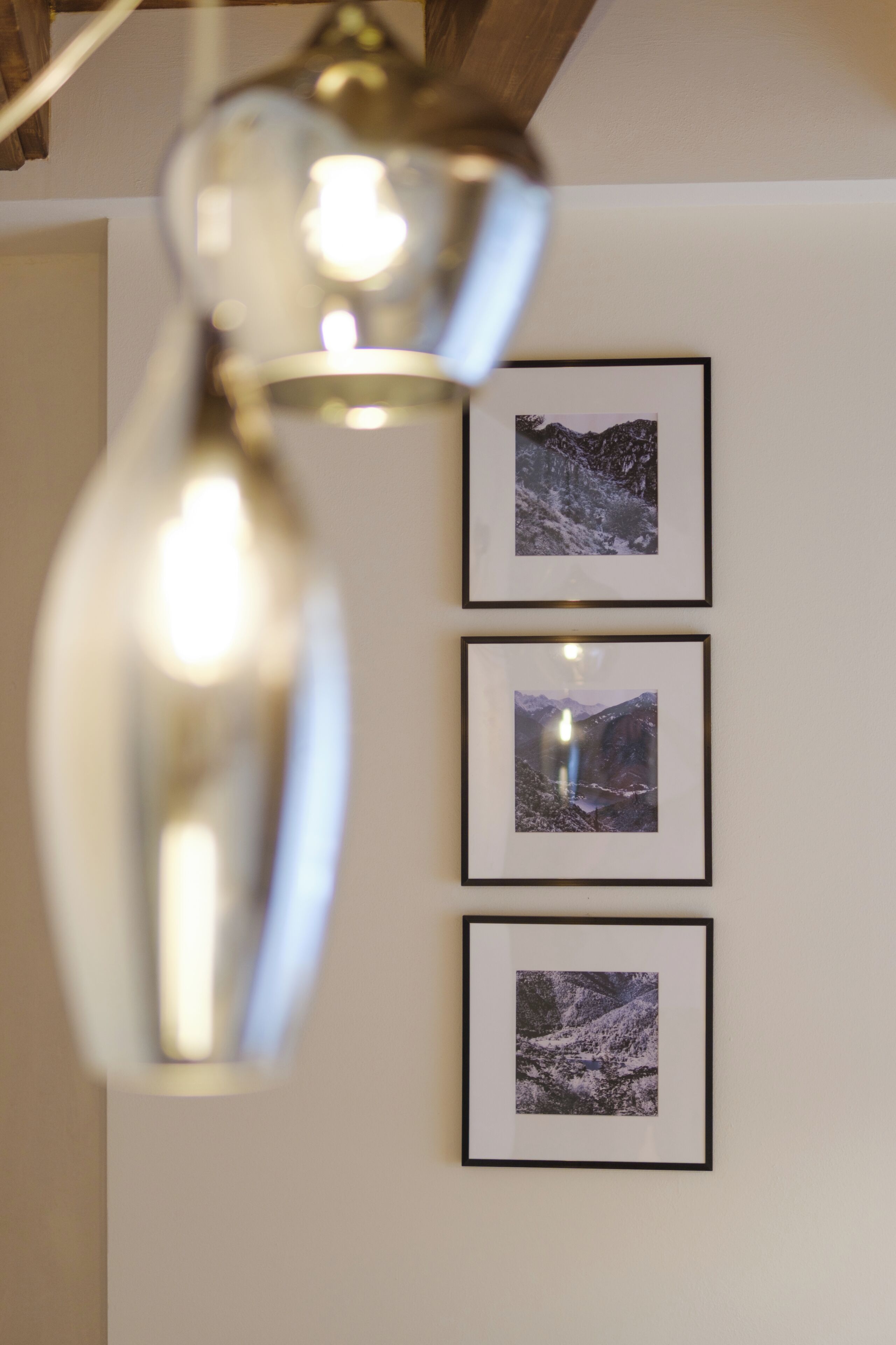 Una lampada a soffitto e tre fotografie incorniciate su una parete.