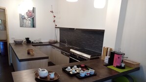 Eine moderne Küche mit Kochinsel, integriertem Backofen und schwarzem Fliesenspiegel.