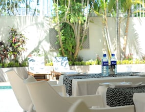 Ein Tisch für zwei Personen mit Blick auf Pool und Grünflächen.