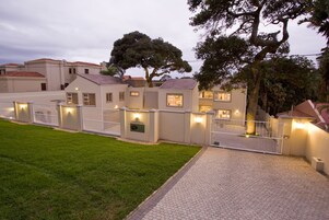 A residential area with houses, a paved walkway, and a gated entrance.