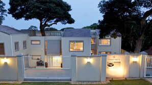 Une maison moderne à deux étages, dotée d’une entrée sécurisée par un portail, d’une pelouse bien entretenue et d’une plaque indiquant l’adresse : 62, avenue Forest.