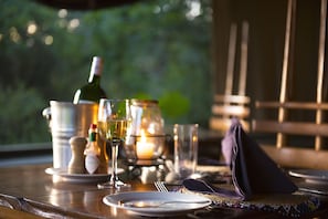 A table set for dining with a candle, wine bottle, and glasses.