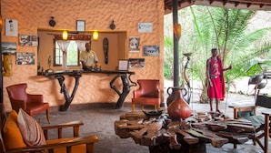 Un interior rústico con muebles de madera, una recepción y una persona vestida con traje tradicional.