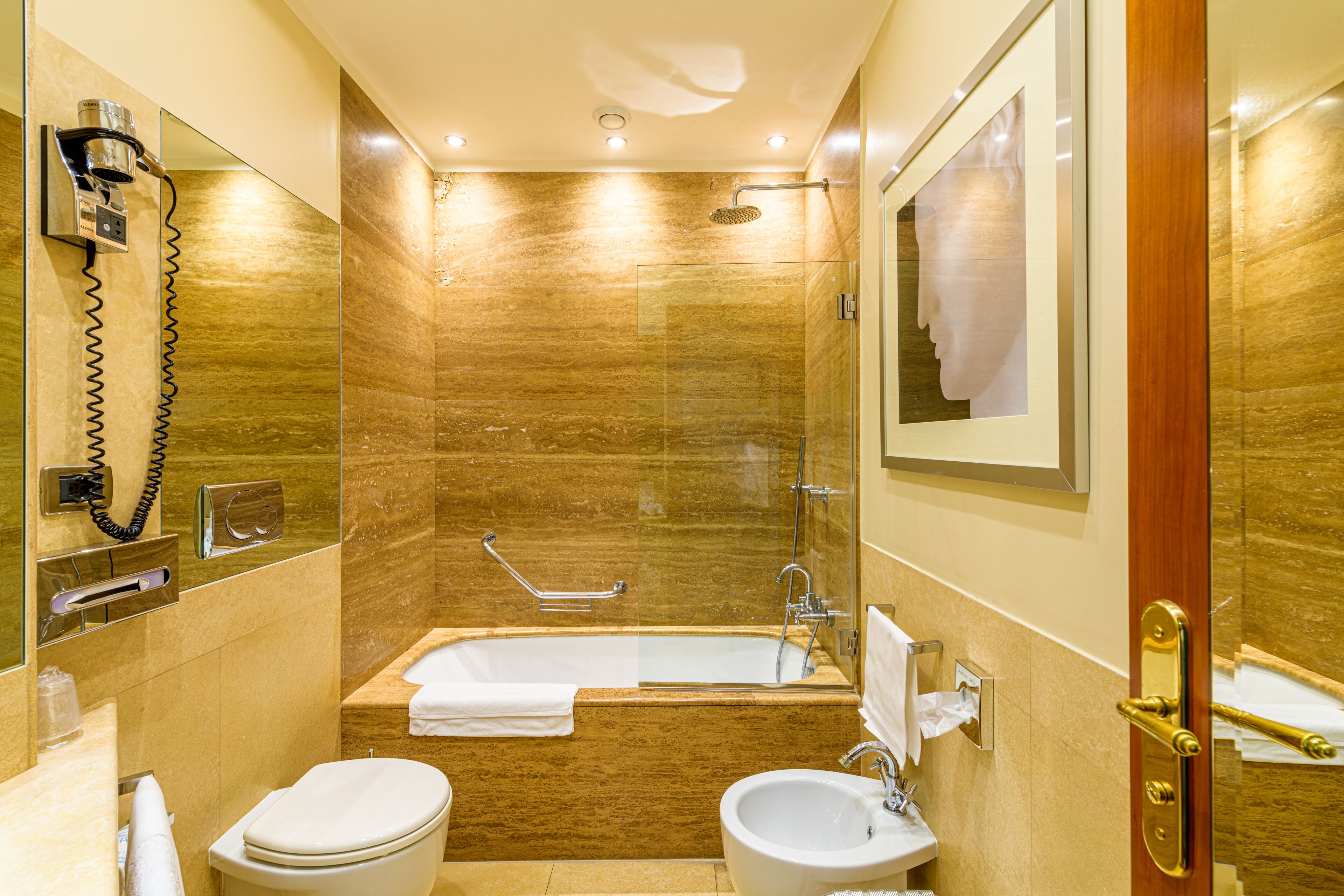 A bathroom with a bathtub, toilet, and sink, all with white fixtures.