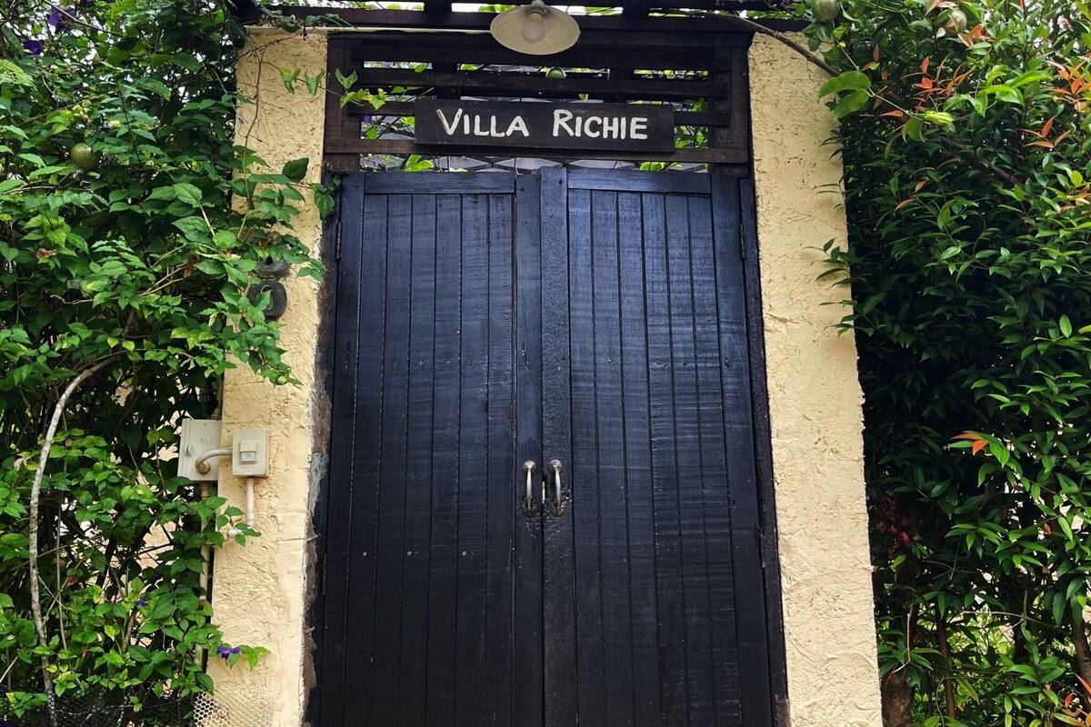 Une porte noire sur laquelle est fixée une plaque portant l’inscription « Villa Richie ».