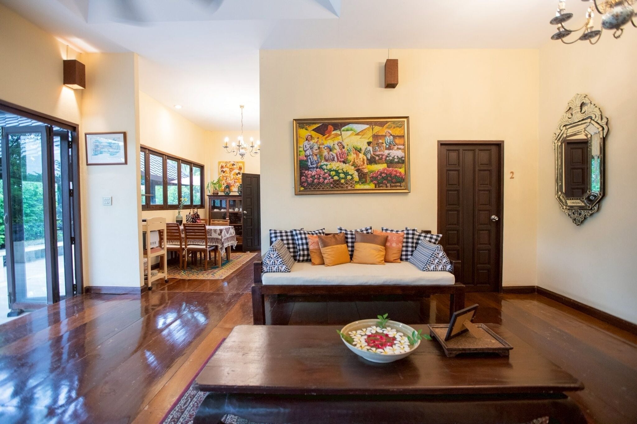 A spacious living area with a sofa, a dining table, and a painting on the wall.