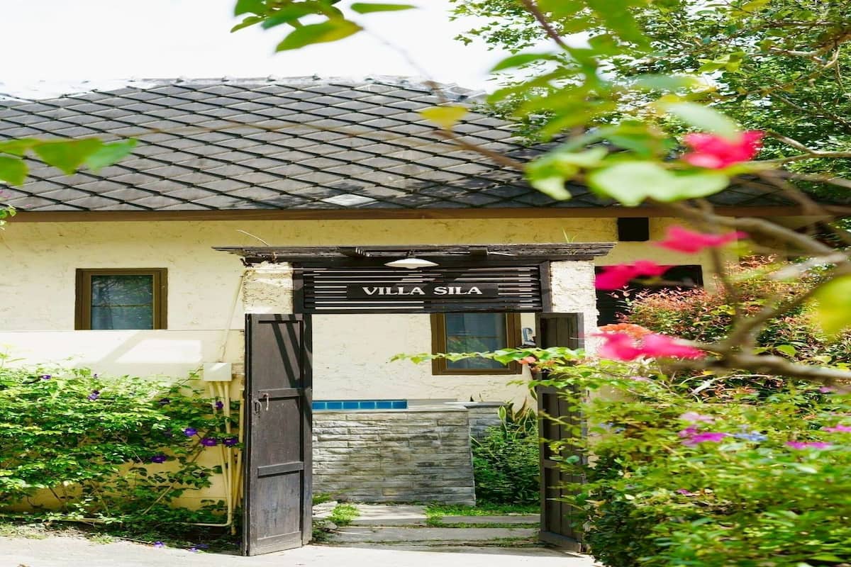 Une villa appelée « Villa Sila », dotée d’un toit en tuiles, d’un mur en pierre et d’un portail en bois.