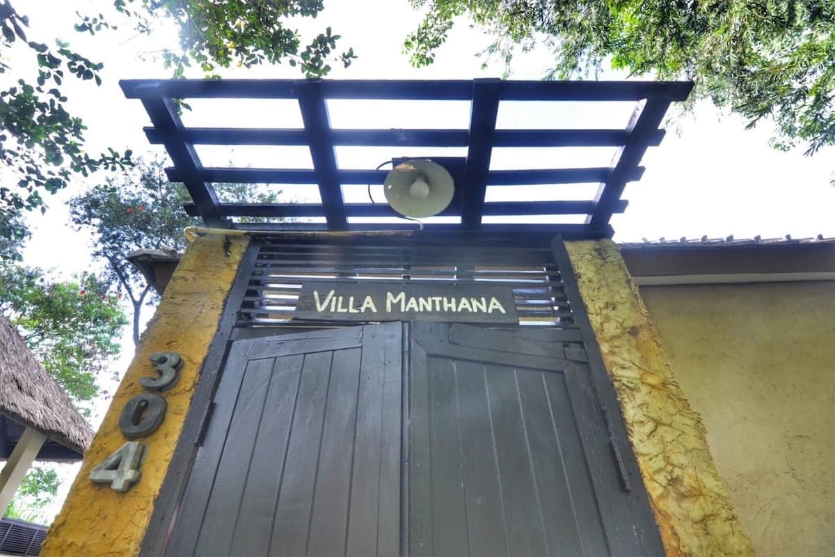 Une entrée fermée par un portail sur lequel on peut lire l’inscription « Villa Manthana » et le numéro « 304 ».