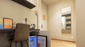 A compact kitchenette with a fridge, a small coffee maker, and a chair. - La Loggia de' Banchi (La Spezia)