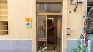 A building entrance with a glass door, a stairway leading inside, and a number '31' on the wall. - La Loggia de' Banchi (La Spezia)