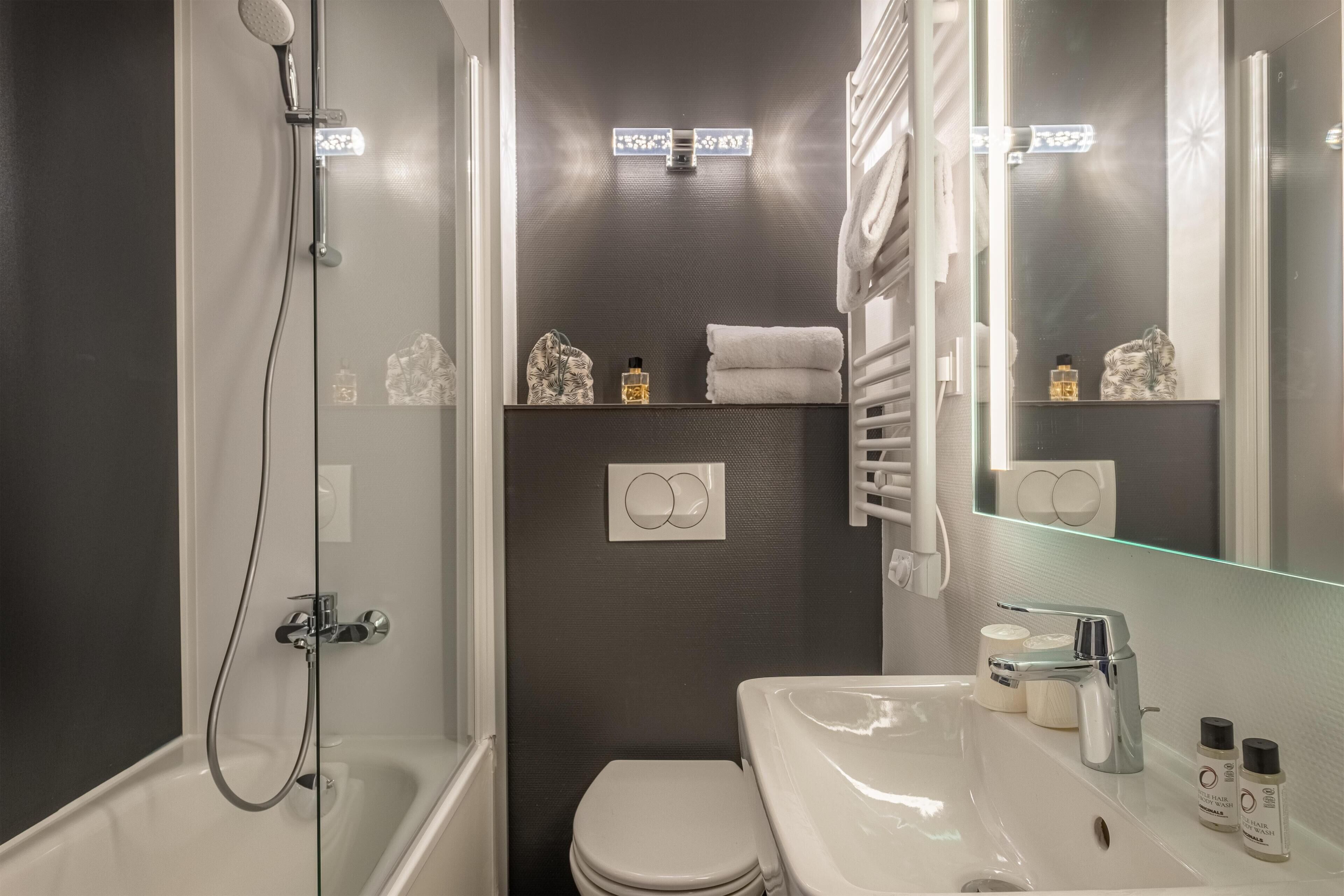 A modern bathroom with a bathtub, toilet, and sink.