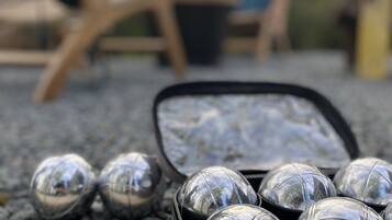 A close-up of a metallic object with a reflective surface, possibly a part of a vehicle or machinery, with a blurred background.