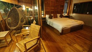 A wooden room with a bed, a chair, and a hanging chair. - Tique Series Boutique Resort (Rayong)