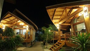 A wooden cabin-style building with a covered porch and a staircase leading to the entrance. - Tique Series Boutique Resort (Rayong)