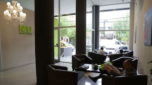 A hotel lobby with a chandelier, large windows, and a reception desk. - Hotel Neu 354 (Neuquén)