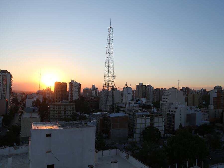 A cityscape at sunset with a prominent communication tower.