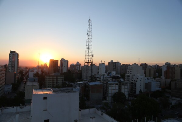 Un paisaje urbano al atardecer, con una torre de comunicaciones destacada.
