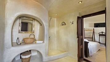 A bathroom with a large sink, mirror, and shower.