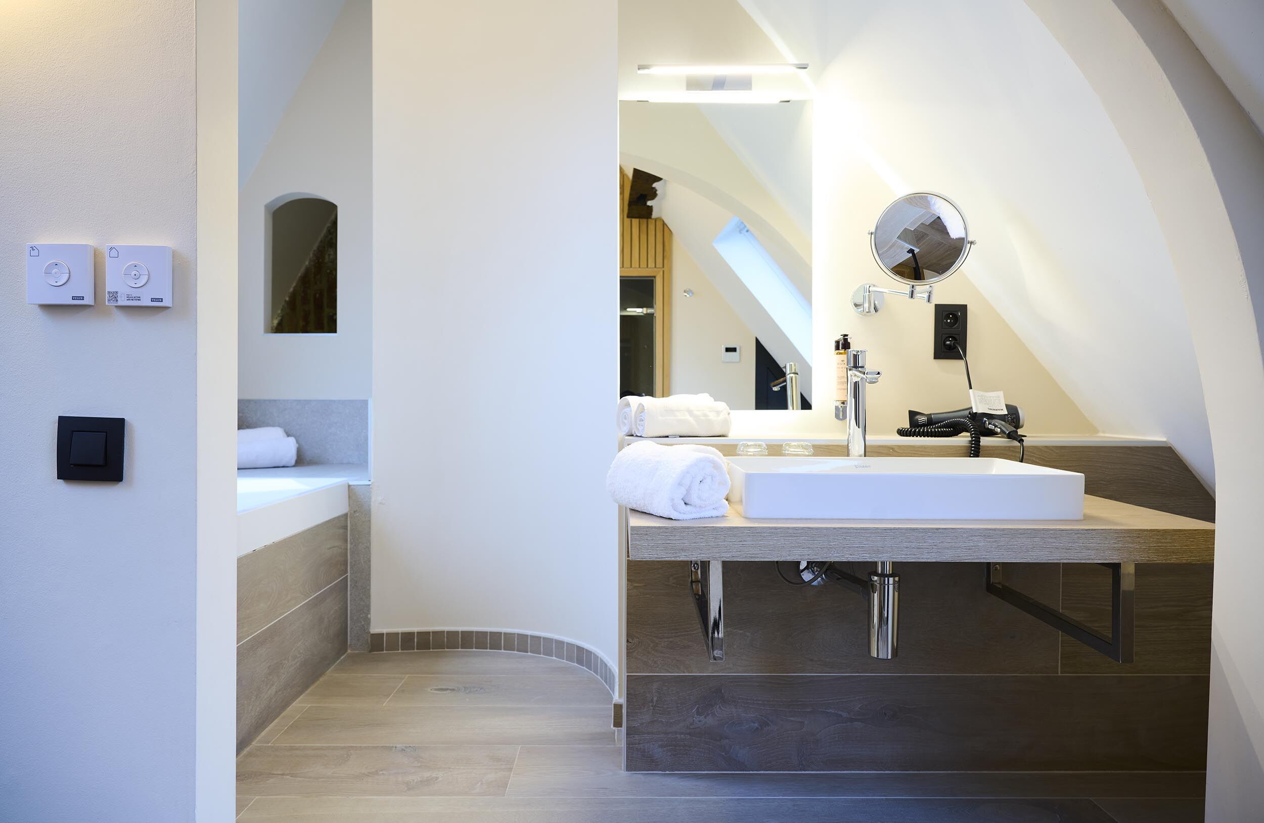 Een moderne badkamer met een ingebouwd wastafelmeubel, een spiegel en een handdoekrek.
