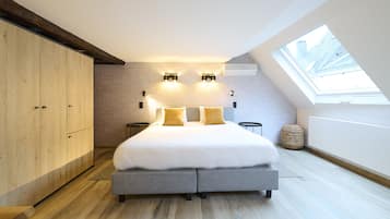 Un dormitorio moderno con tragaluces, una cama grande y un armario de madera.