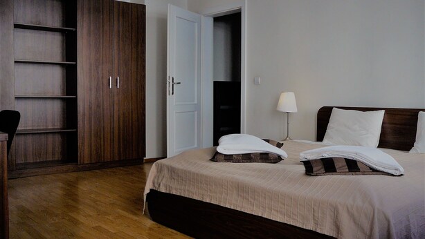 A hotel room with a bed, a wardrobe, and a door to a closet. - FUKAS Apartments MEDENA (Bratislava)