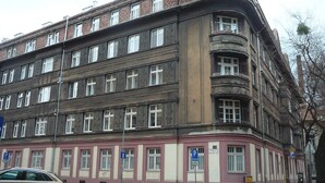 A multi-story building with a classic architectural style, featuring a mix of brick and plaster facades, large windows, and a corner balcony. - FUKAS Apartments MEDENA (Bratislava)