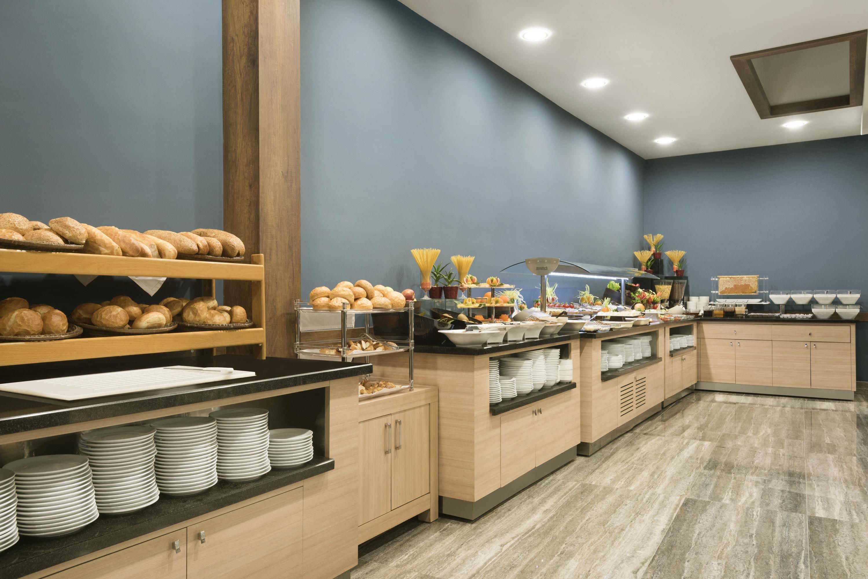 Una mesa de buffet con pan, pasta y diversos platos.