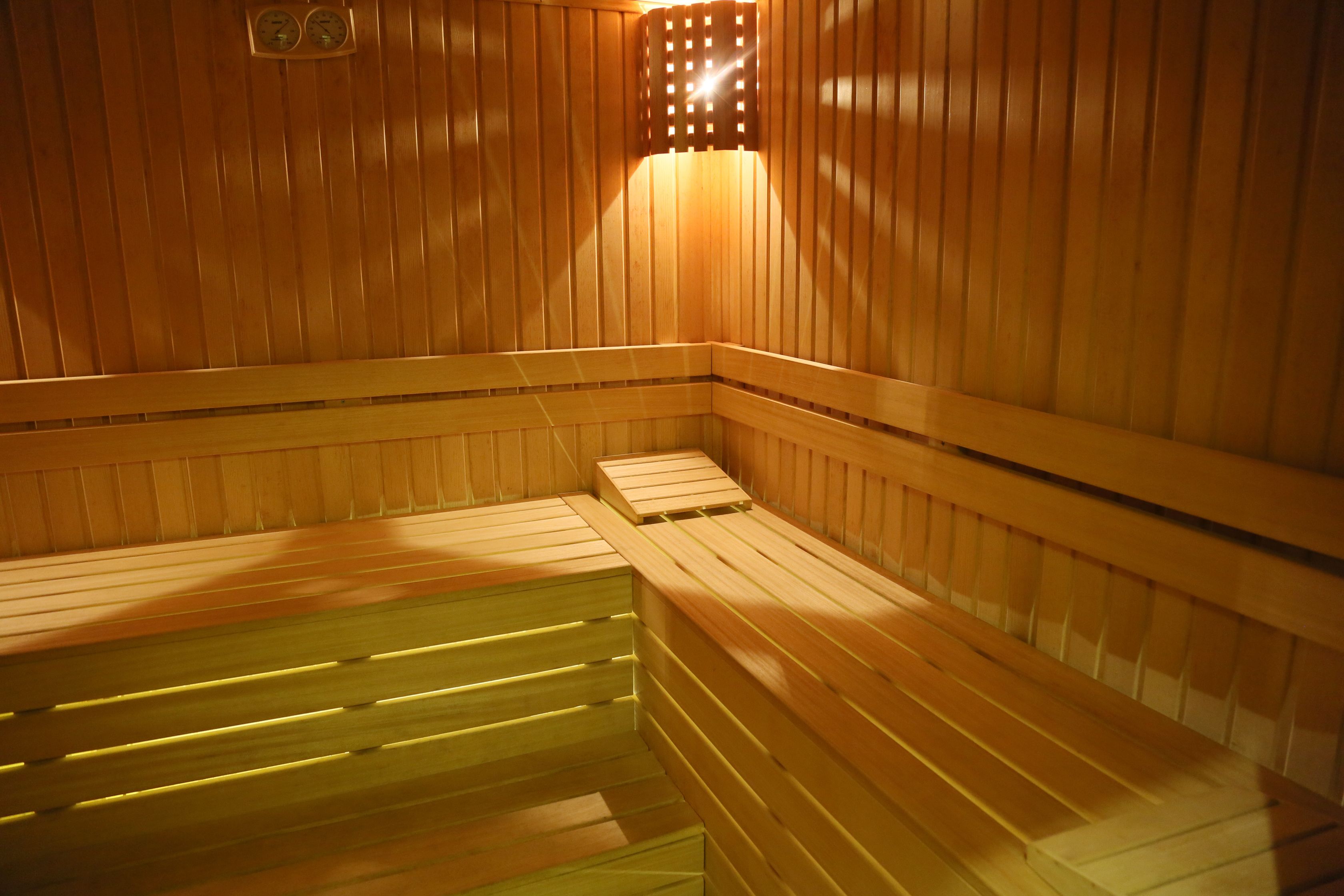 A sauna with wooden benches and a sloped floor.