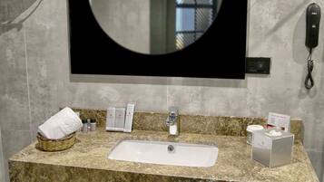 A bathroom with a large mirror, a sink, and a telephone.
