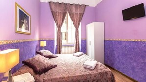 A bedroom with a bed, a nightstand with a lamp, a wardrobe, and a TV mounted on the wall. - Holiday Sunny Roma B&B (Rome)